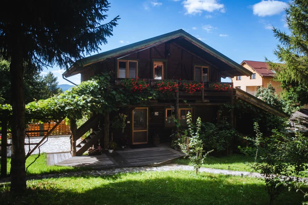 Cabana Bendis — cabana și grădina, într-o dimineață senină.