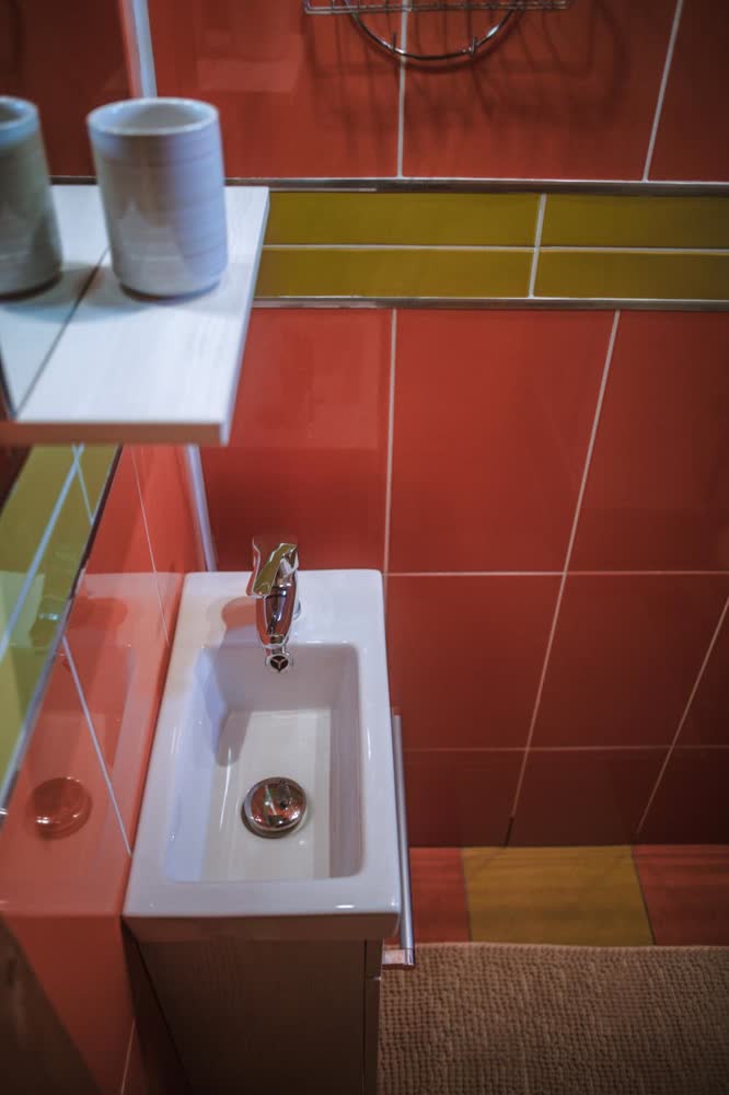 Baia cabanei — lavoarul, pe faianța cărămizie.